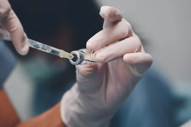 Photo of medical professional getting vaccine from vial