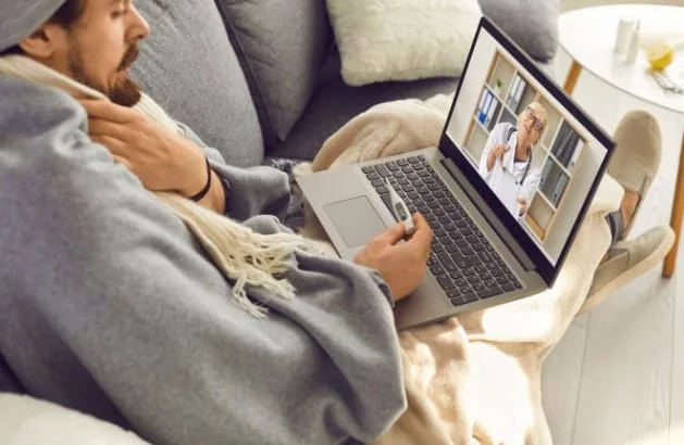 Photo of person sick with the flu doing a telehealth consultation