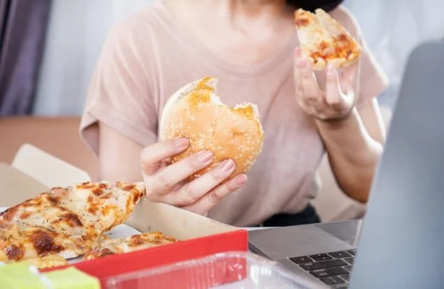 woman binge eating for the blog post on managing disordered eating patterns during the menopause transition