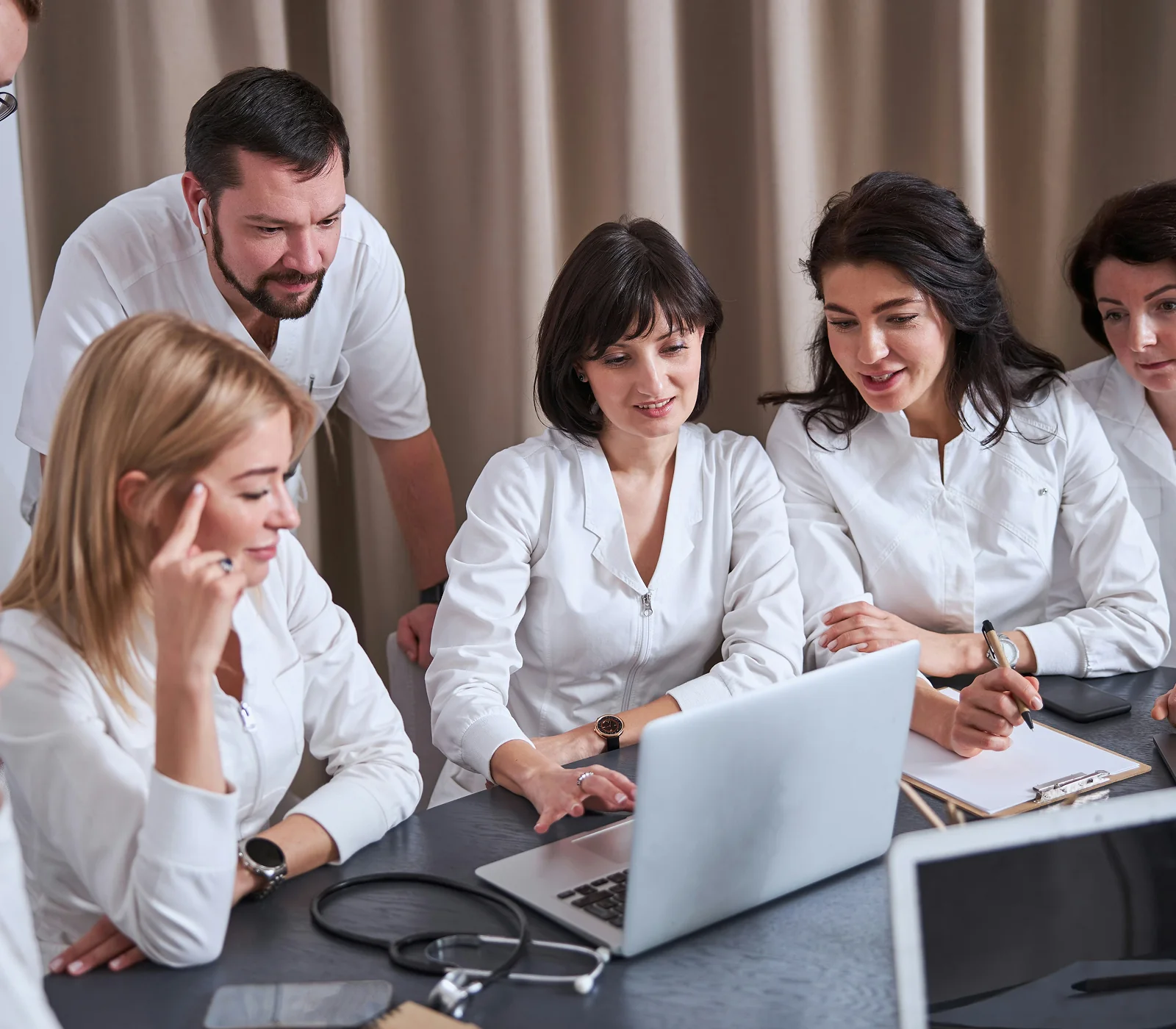 Healthcare professionals reviewing telehealth workflow on a laptop