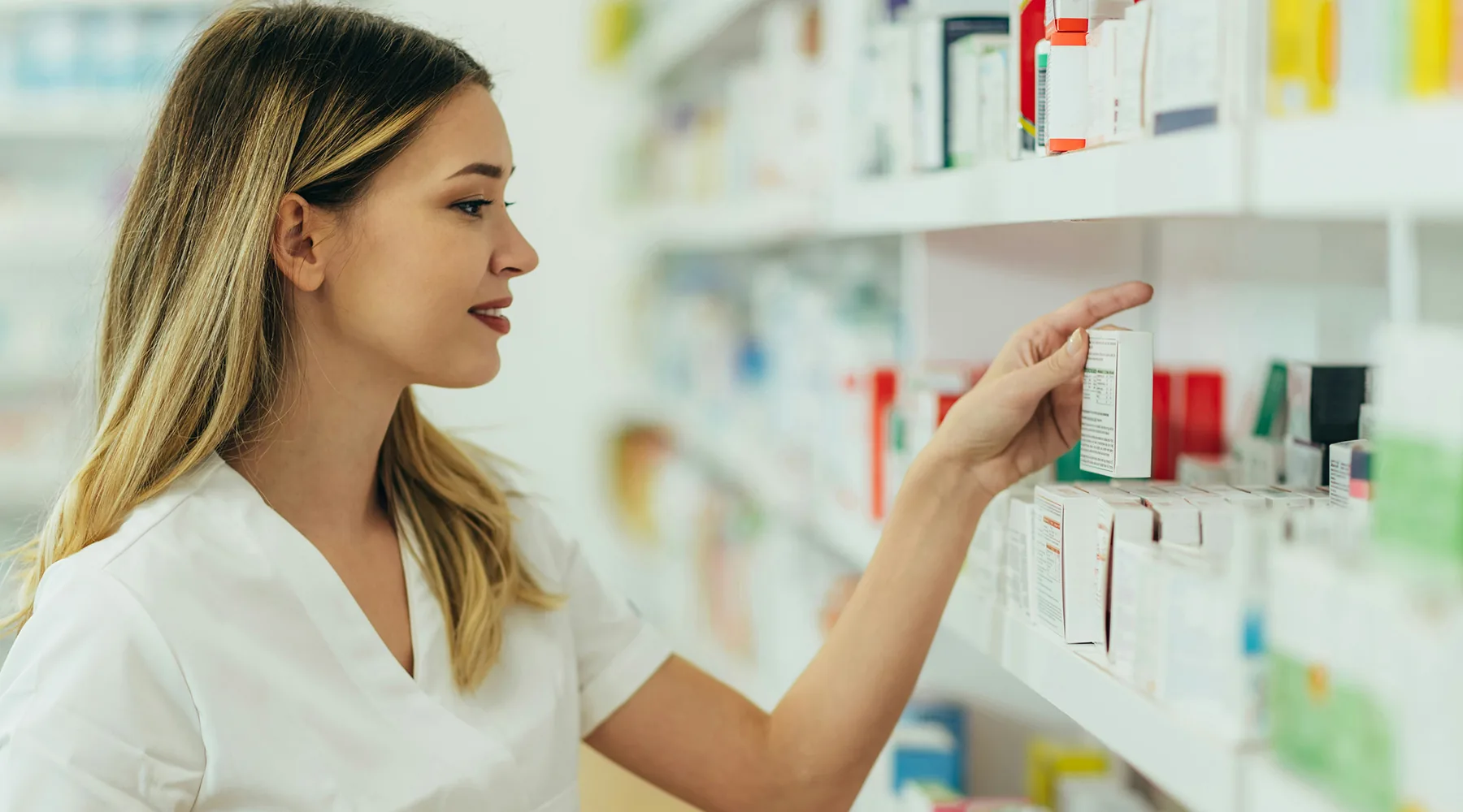 Pharmacy professional reviewing medication shelves