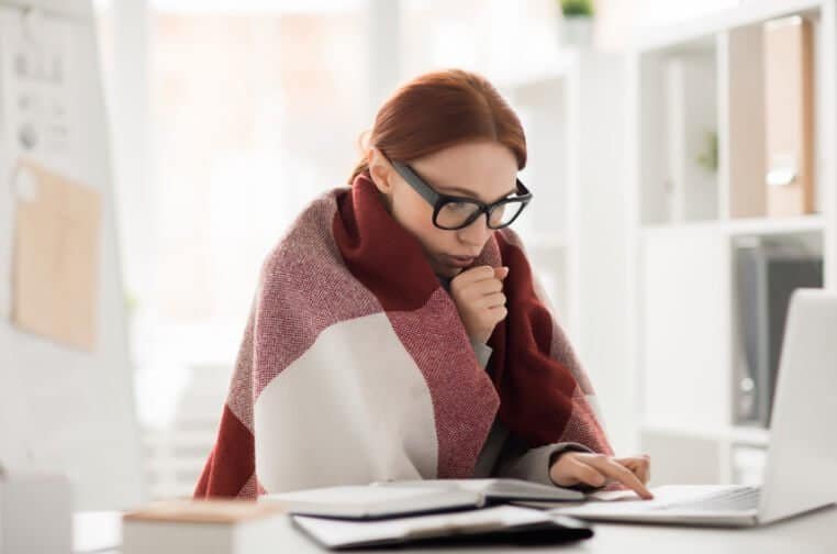 picture of woman with the flu working on her laptop