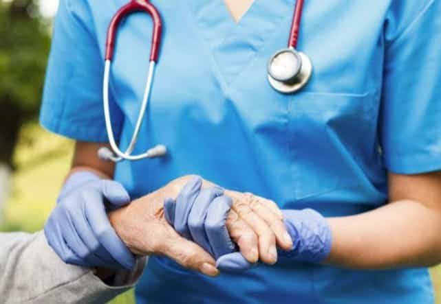 Image of a medical professional holding the hand of an elderly patient