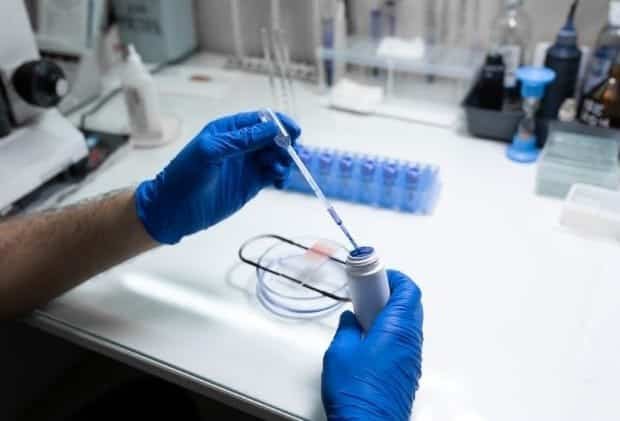 Inside the clinical lab- a technician processes a blood sample using modern equipment